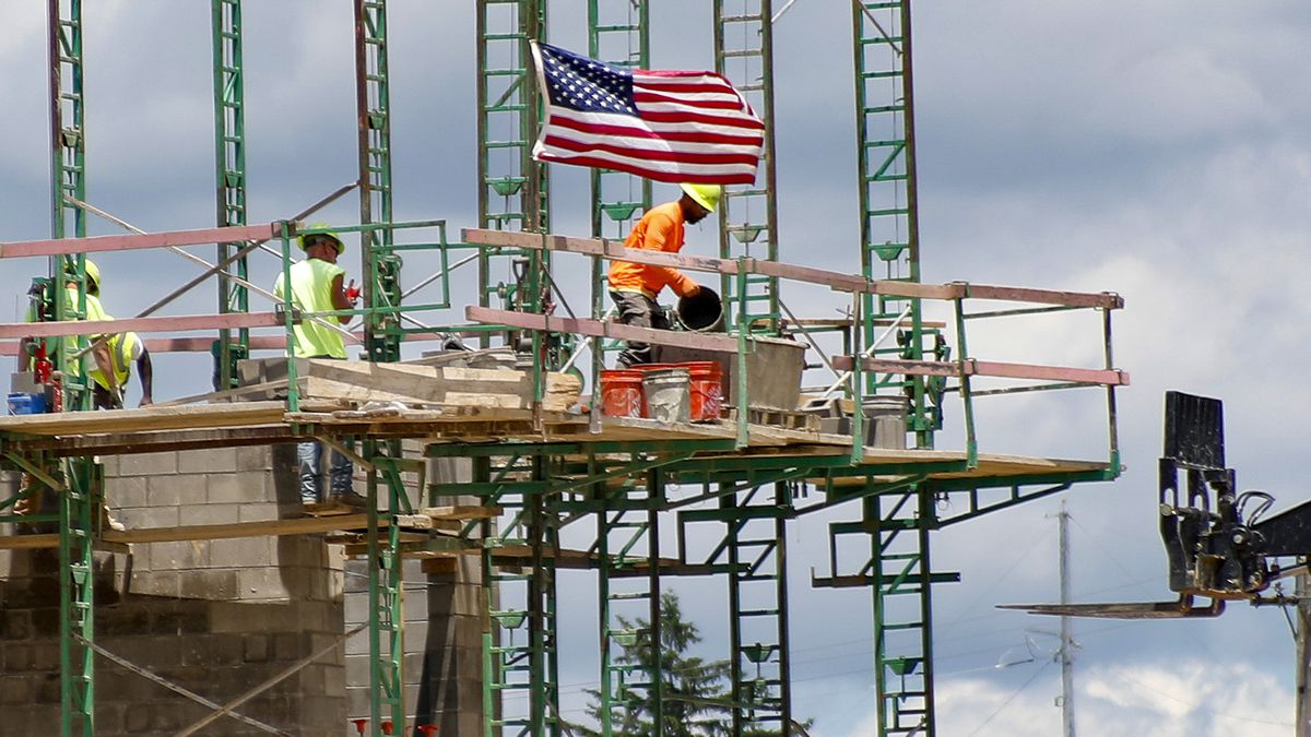 FILE - In this June 11, 2020 file photo, workers on scaffolding lay blocks on one of the larger...