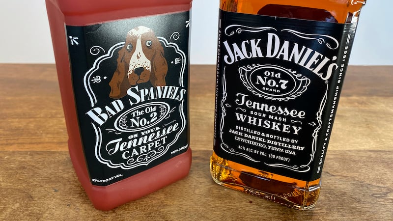A bottle of Jack Daniel's Tennessee Whiskey is displayed next to a Bad Spaniels dog toy in...